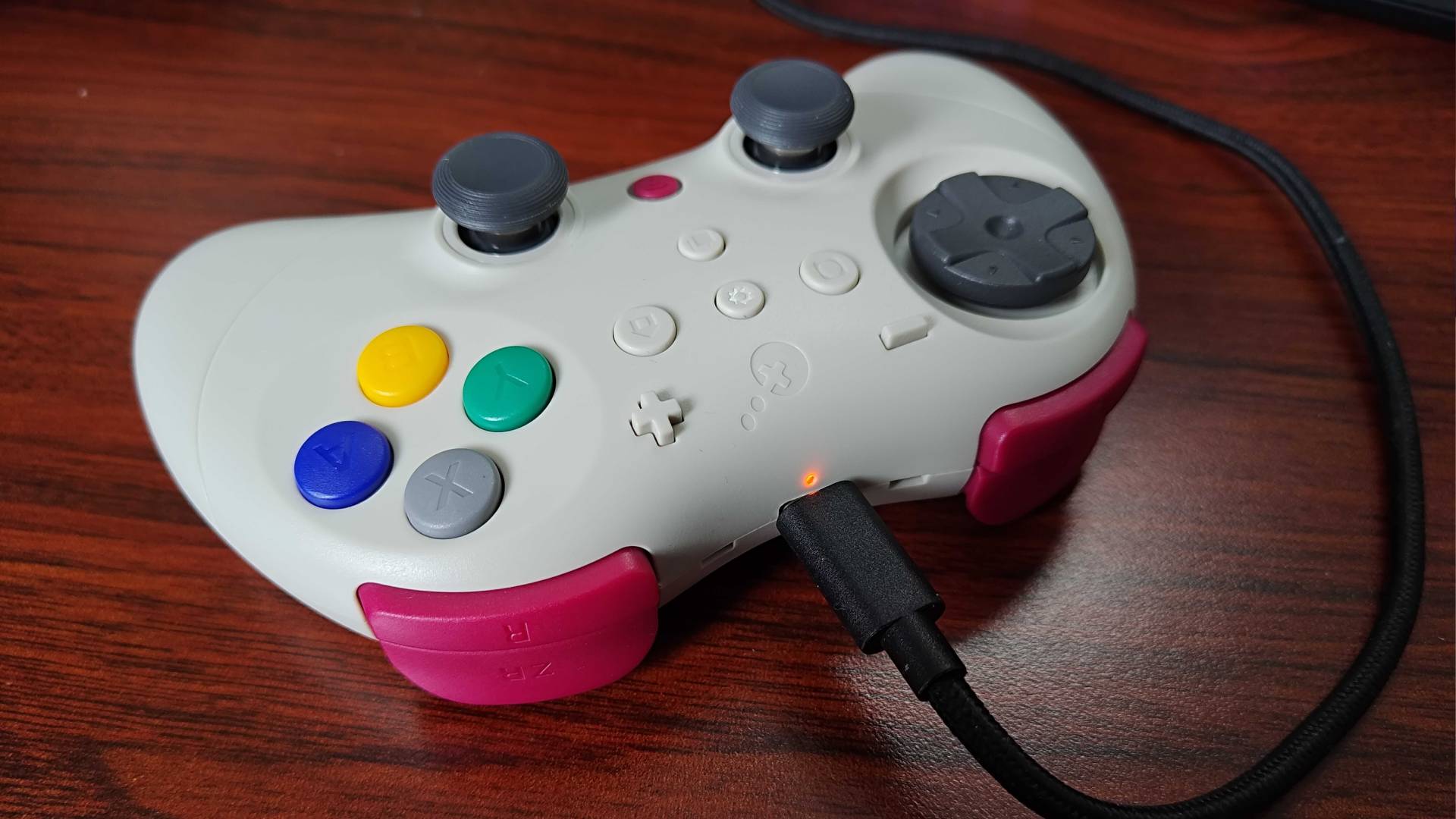 Gulikit Elves 2 Pro with USB-C cable plugged in on woodgrain desk.