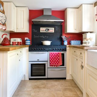 kitchen with cream cabinets and red wall