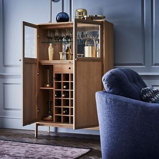 room with wooden floor and cabinet with drinks