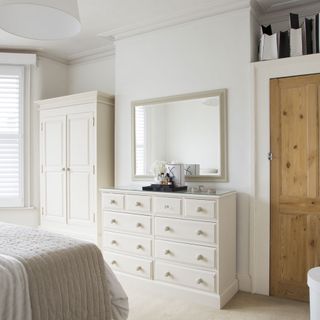 white master bedroom with carpet flooring and cupboard