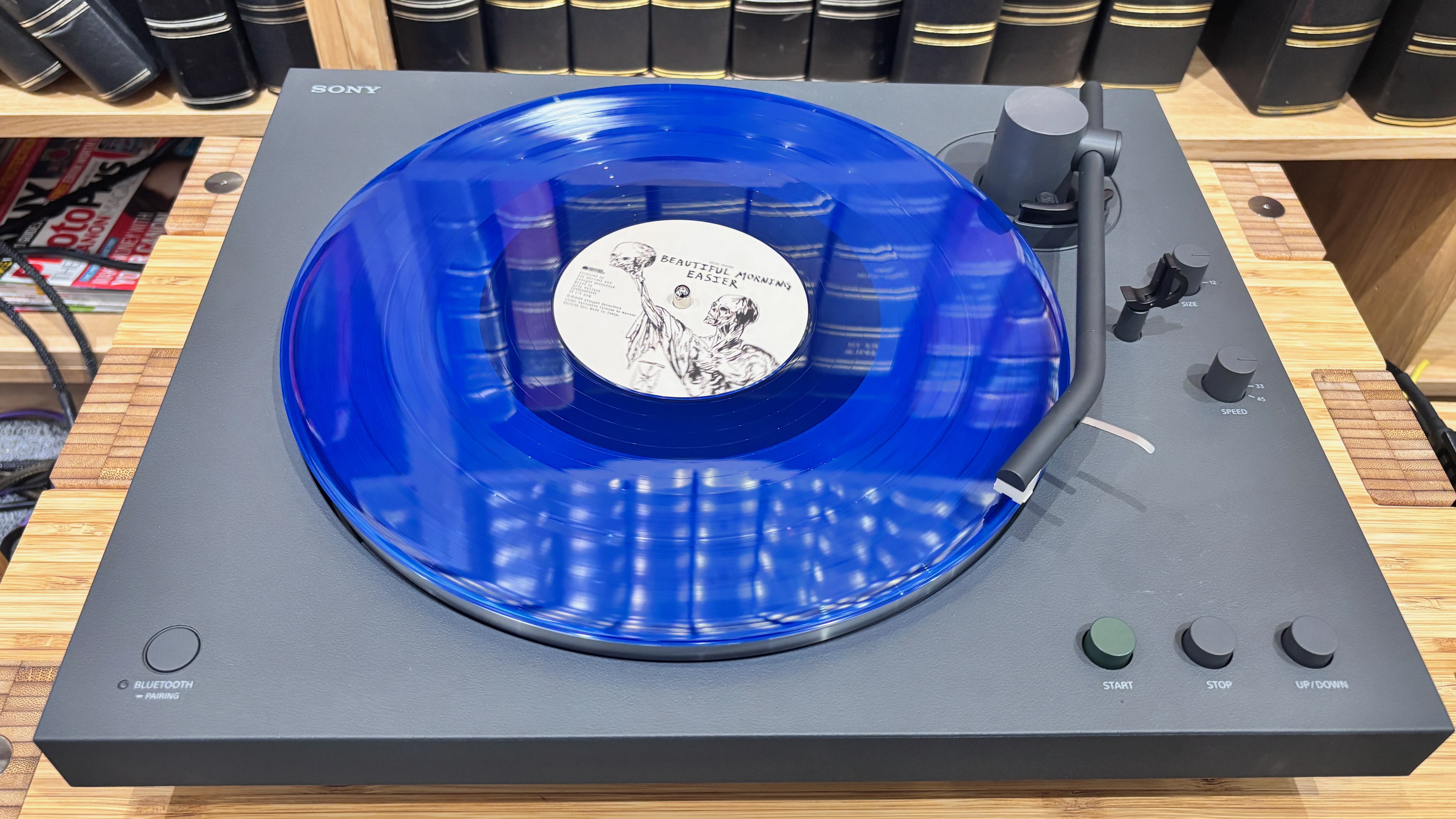 Sony PS-LX3BT turntable on wooden hi-fi rack with blue vinyl on platter