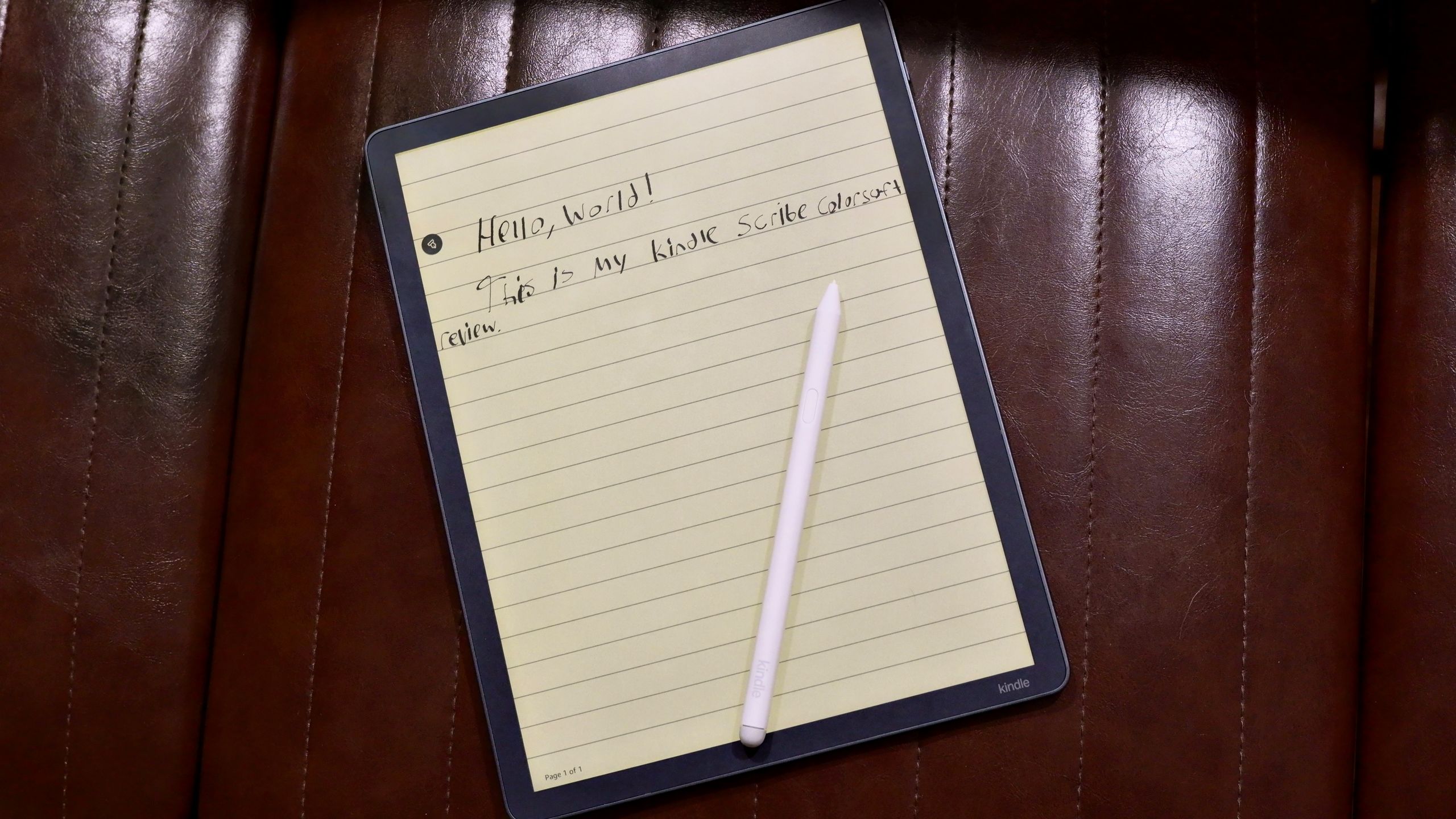 Amazon Kindle Scribe Colorsoft on a chair with a pen on top and the text reading, Hello, world! This is my Kindle Scribe Colorsoft review.