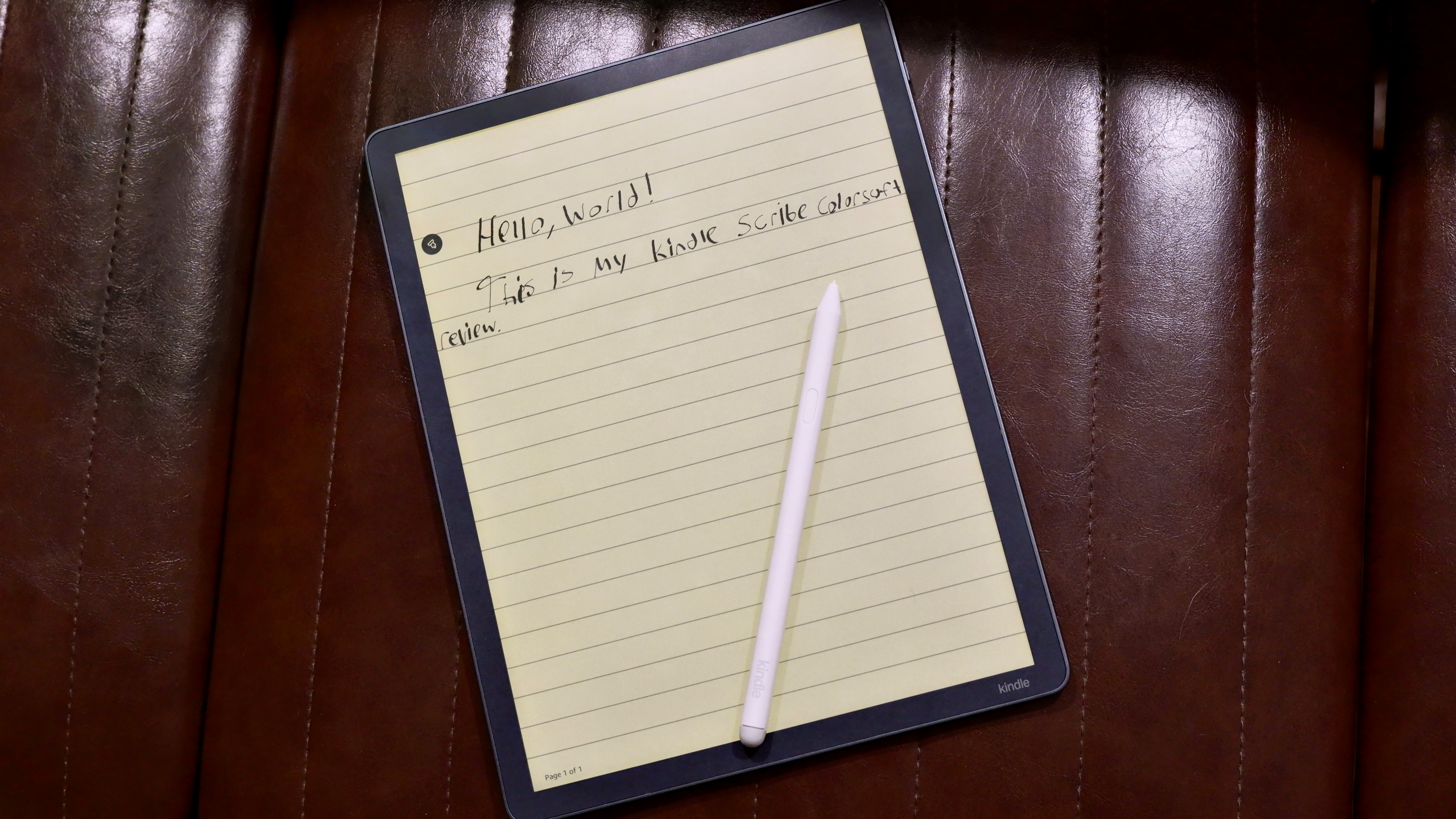 Amazon Kindle Scribe Colorsoft on a chair with a pen on top and the text reading, "Hello, world! This is my Kindle Scribe Colorsoft review."