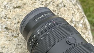 Closeup of Sony FE 16-35mm F2.8 GM II lens outdoors on a rock