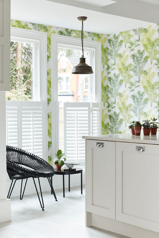 Tier on Tier Shutters in a kitchen with green leaved wallpaper and white cabinetry