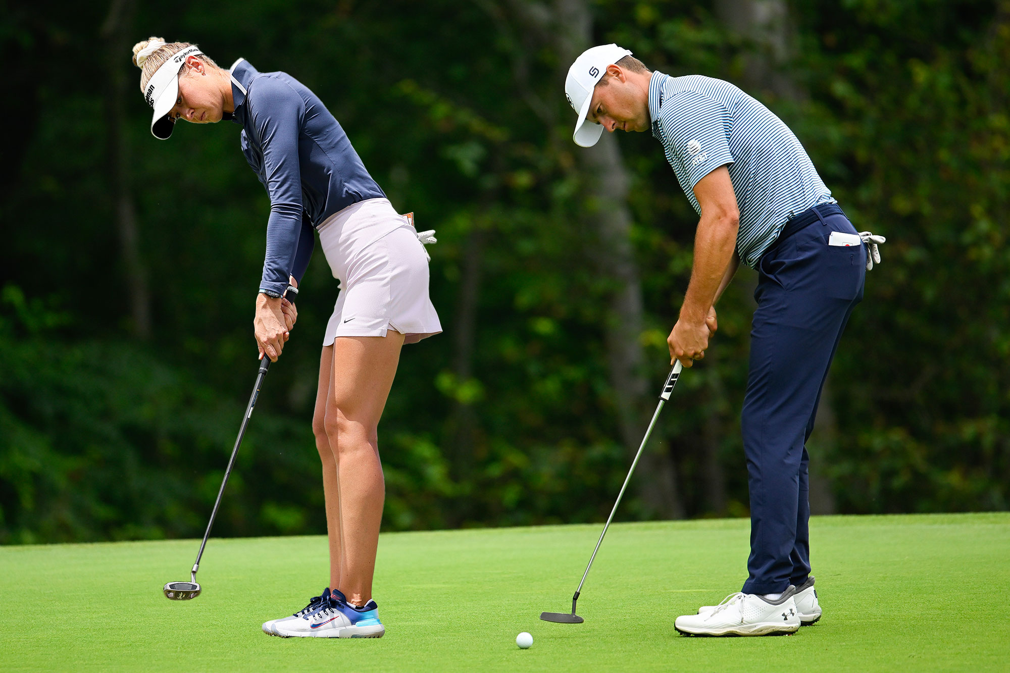 Jordan Spieth and Nelly Korda both putting on the green using their left hand low putting grip, which has helped them to win multiple Major Championships