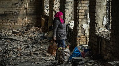 A woman tries to save some personal belongings from her destroyed flat in Arkhanhelske, in Kherson region