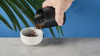 a black plastic coffee doser with an aesthetically pleasing design and a curved built-in LED screen