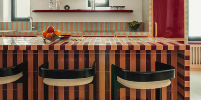 striped tile kitchen island with peachy orange and maroon tiles