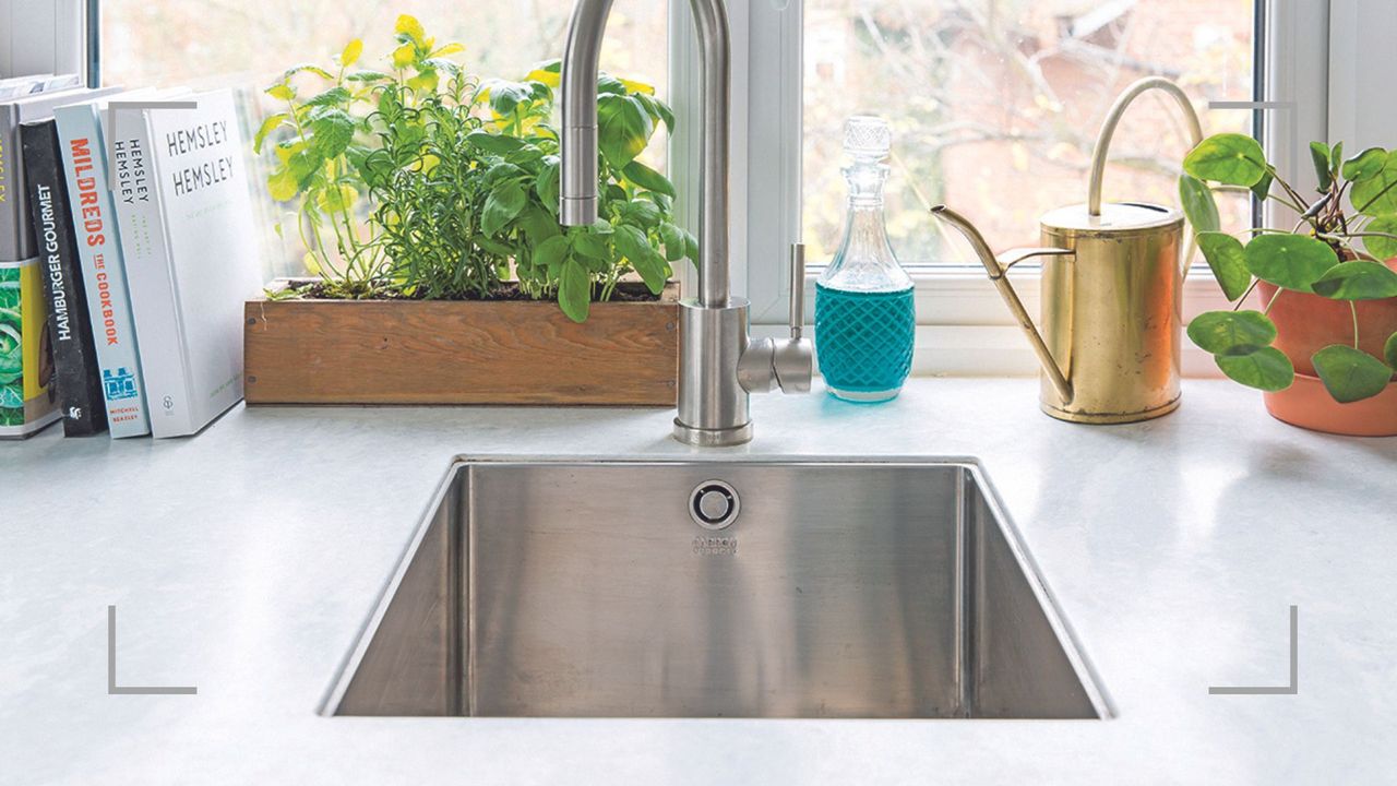 Kitchen with white marble worktop and integrated stainless steel sink to consider how to clean a stainless steel sink