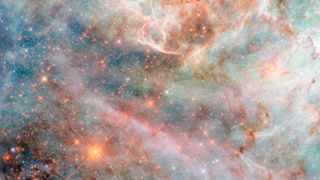 A part of a nebula in space made of layers of gas and dust clouds in different colors, from blue and green shades to pink, red and black.