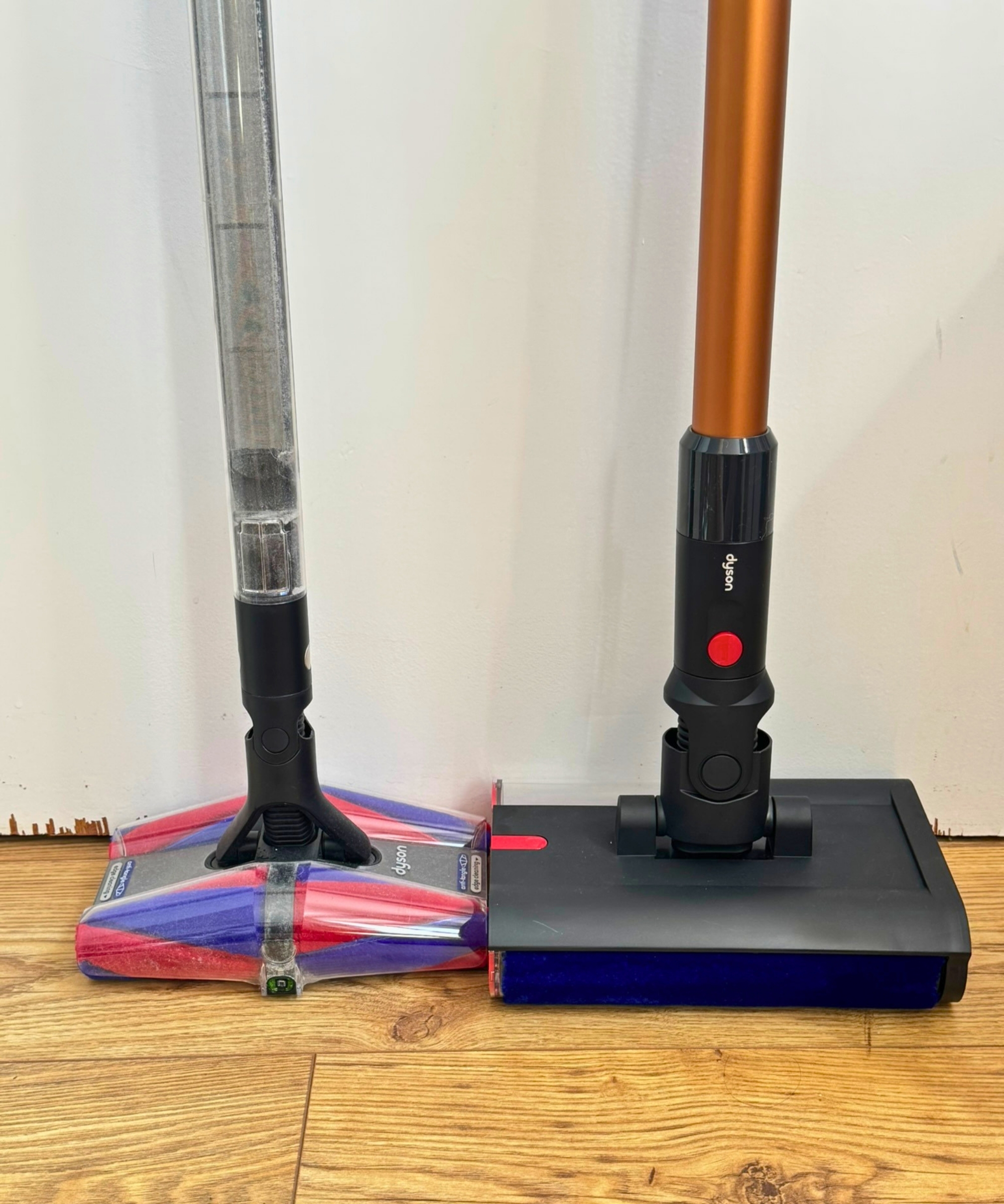Floorheads and wands of the Dyson PencilVac Fluffycones and the Dyson PencilWash against white door.