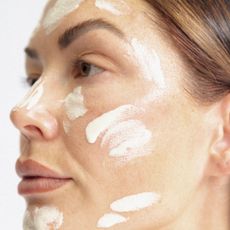 A woman with moisturiser dotted over her face