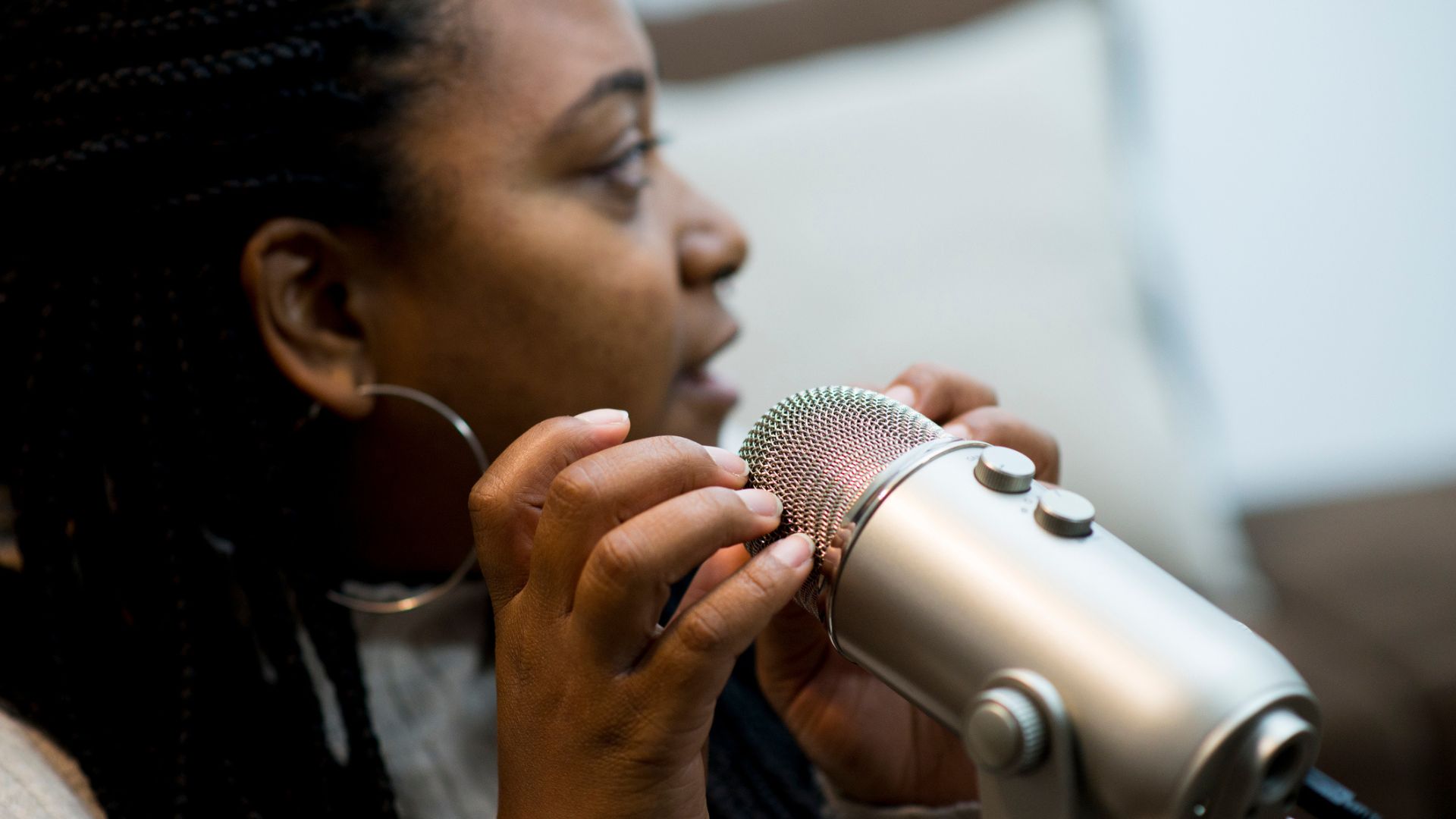A woman tapping her fingers on a microphone while creating ASMR for sleep