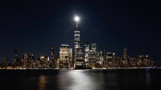 Views of the Super Pink Moon above lower Manhattan and One World Trade Center in New York City on April 26, 2021, from Jersey City, New Jersey.