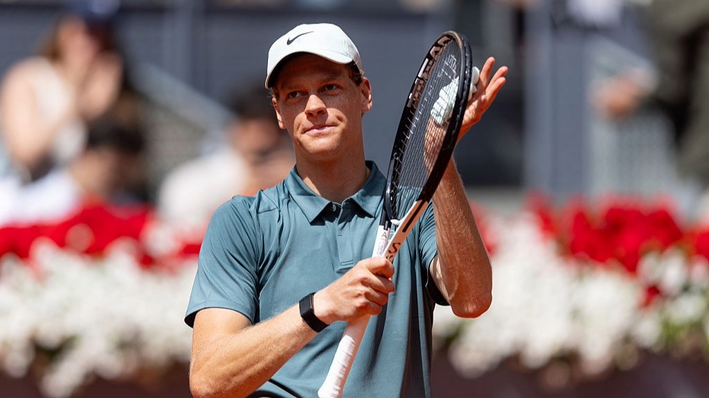 Jannik Sinner uses his tennis racket to applaud the crowd after winning a match at the Madrid Open 2026