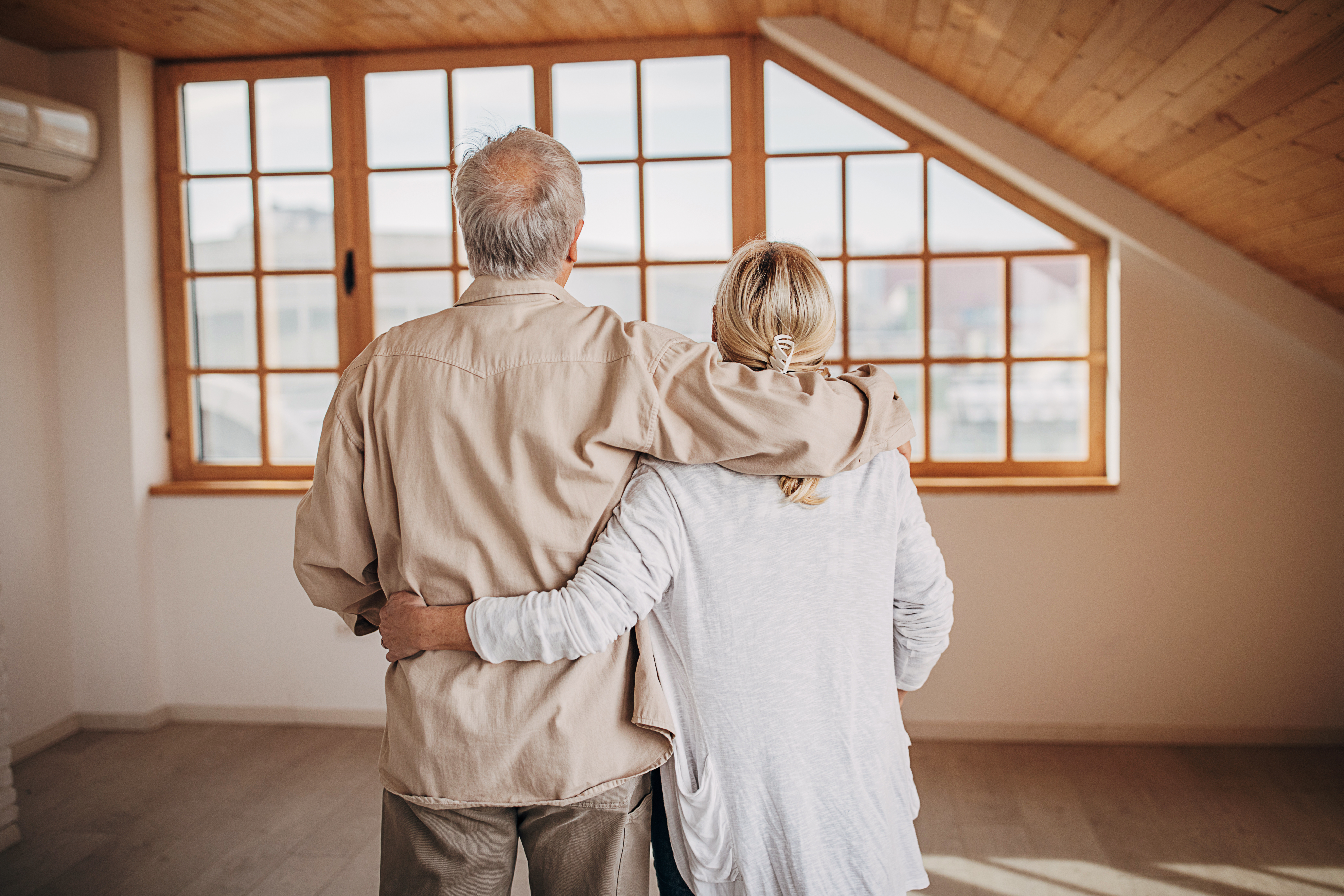 Two people, senior married couple in their empty new apartment.