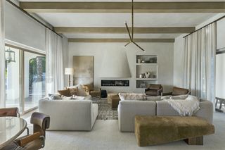 A living room with a muted carpet and a green rug on top