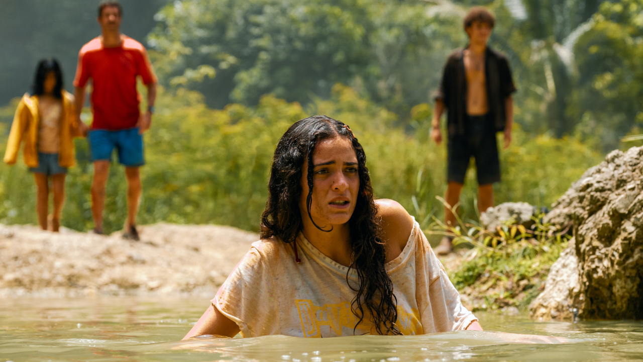 Luna Blaise wades anxiously through water as others watch on in Jurassic World Rebirth.