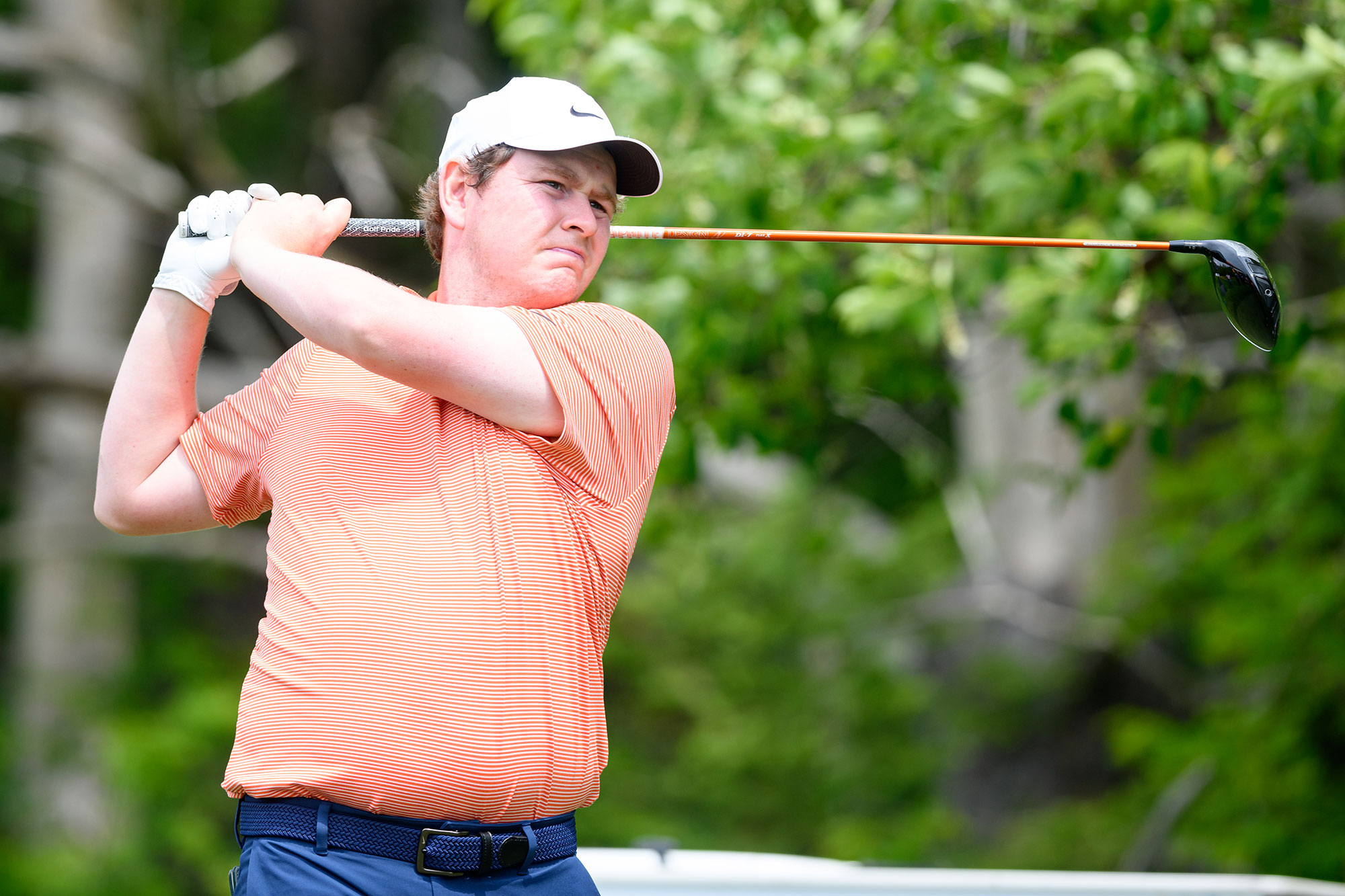 Robert MacIntyre in the finish position with driver after hitting a tee shot, watching the ball travel off the tee