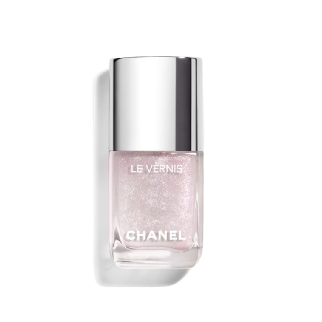 A product shot of the Chanel Le Vernis long-wearing nail varnish in shade Beach Icon (a pearl and pink glitter polish), on a white background