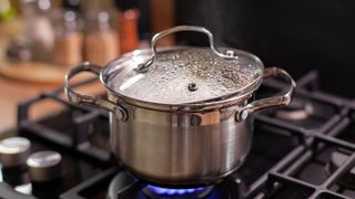 A pot boiling on a stove with a lid on top