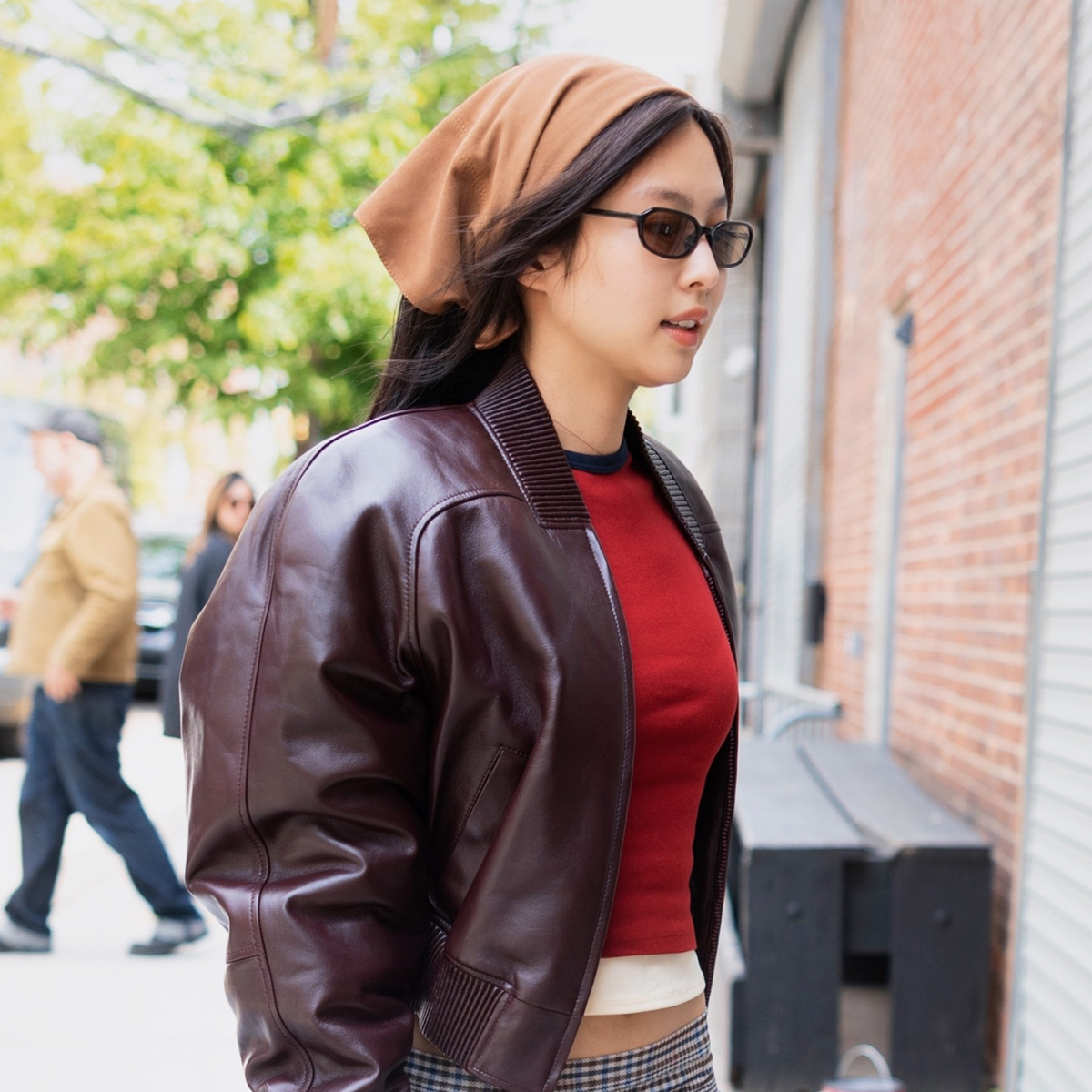 Jennie Kim wearing a leather jacket, sheer midi skirt, and wedge-heel thong sandals in NYC