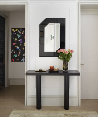 An entry table decor idea with black modern table and black and white artwork