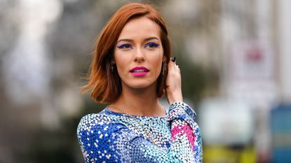 Stunning Woman with Blue and Gold Face Paint and Feathers in Her