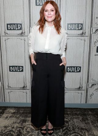 Julianne Moore in a white blouse and black trousers