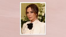 Image of Victoria Beckham smiling with brunette hair in an updo, wearing a white blazer and shirt with black pussy bow tie, on a light pink background