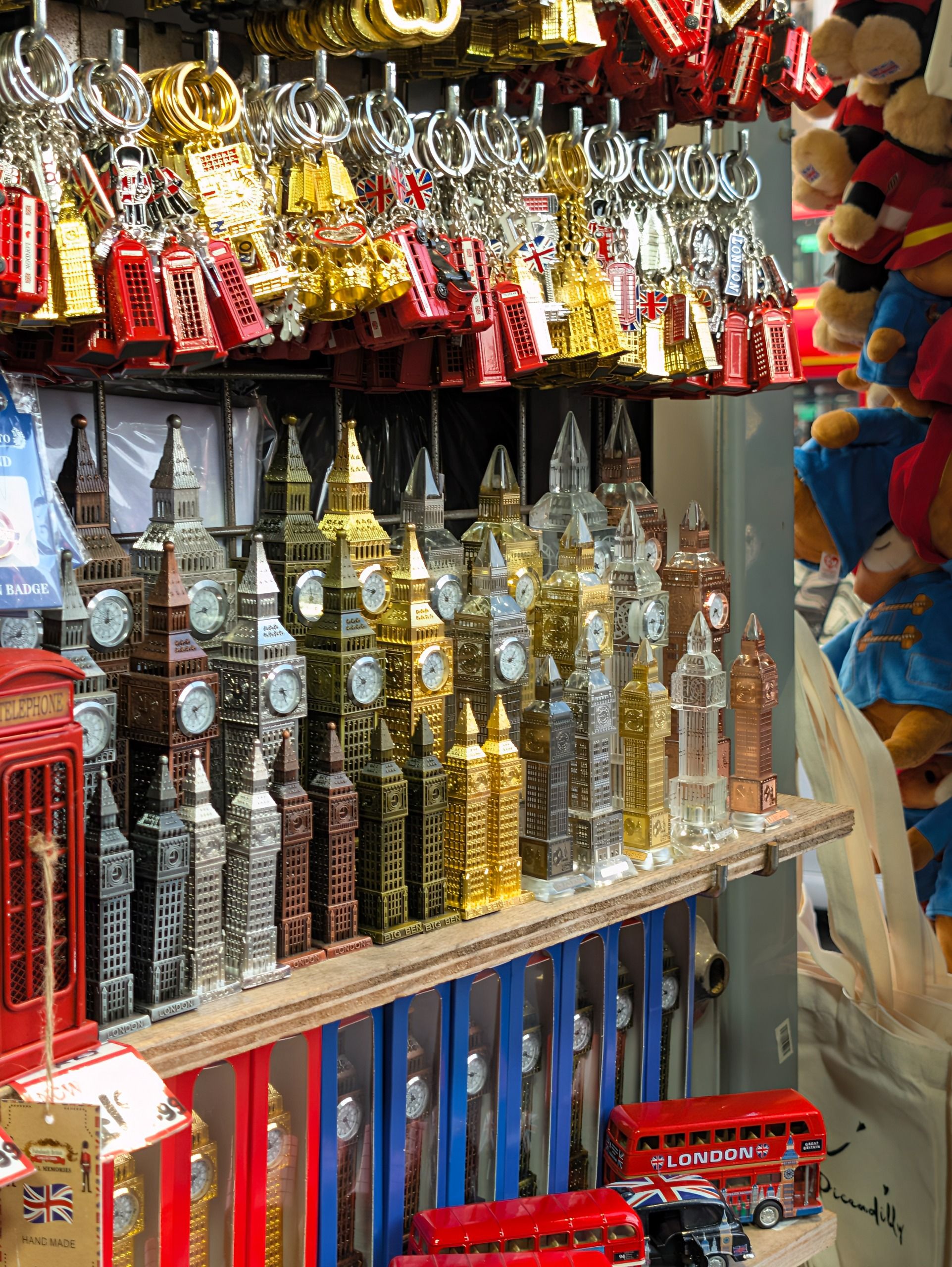 Souvenir shop display packed with London-themed keyrings, miniature Big Ben clocks, red buses and telephone boxes.