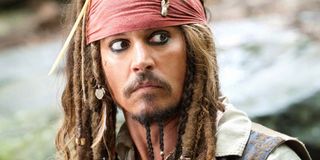 Johnny Depp with a red bandana on in Pirates Of The Caribbean glancing at something out of the corner of his eye.