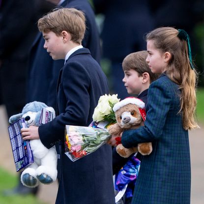 Prince George, Princess Charlotte and Prince Louis holding gifts from the public on Christmas Day 2024 