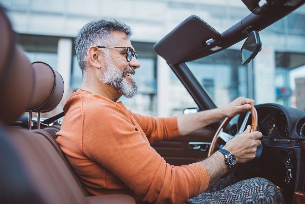 Man driving vintage car through the city