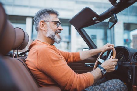 Man driving vintage car through the city