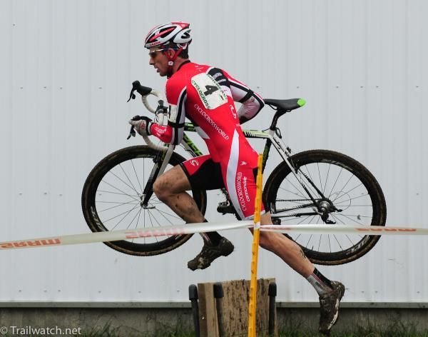 Dylan McNicholas (Cyclocrossworld.com) sprinting over the barriers
