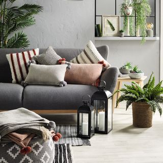 living room with sofa pom pom cushions and potted plants
