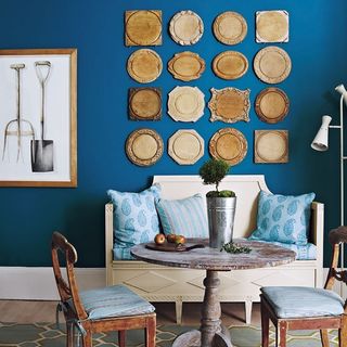 blue wall room with cushions on wooden sofa and chairs