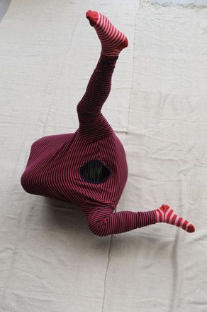 Headless model in a red and black striped outfit with red and white socks