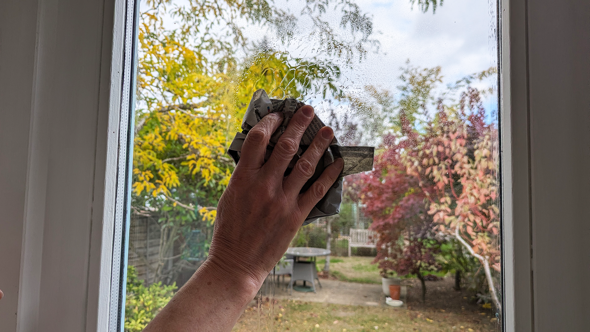 Cleaning window with newspaper