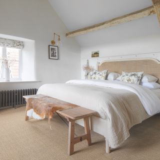bedroom in farmhouse renovation with white walls and neutral decor