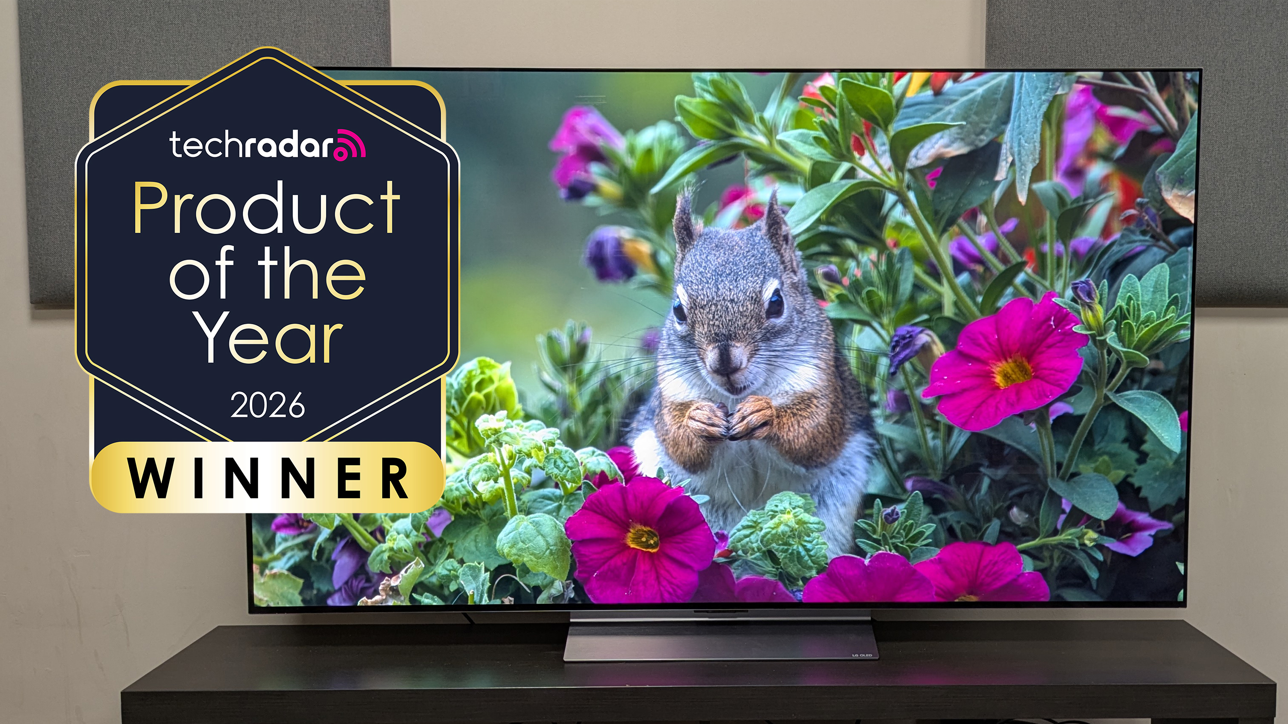 The LG C6 showing a squirrel and colorful flowers on the screen, with a logo saying "TechRadar product of the year 2026"
