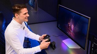 A promotional image showing a man in a white shirt happily playing a game on a Samsung Odyssey 3D monitor