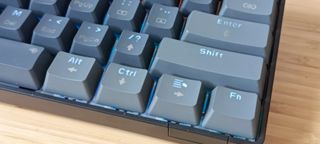 A grey Sablute SG KM61 keyboard sitting on a wooden desk