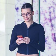 Hailey Bieber wearing blue track pants and black sneakers in Beverly Hills