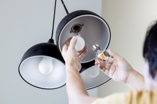 person replacing old bulb with an LED bulb
