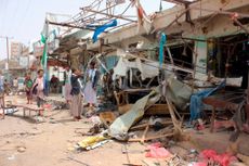 Yemenis gather next to the destroyed bus at the site of a Saudi-led coalition air strike, that targeted the Dahyan market the previous day in the Huthi rebels' stronghold province of Saada on