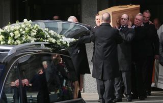 Pallbearers carry the coffin of the late actor Frank Kelly