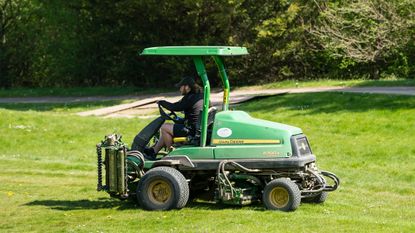 Greenkeeper driving a John Deere vehicle